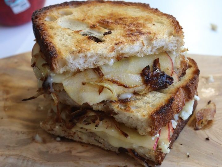 Pazazz and Brie grilled cheese sandwich sitting on a wooden surface